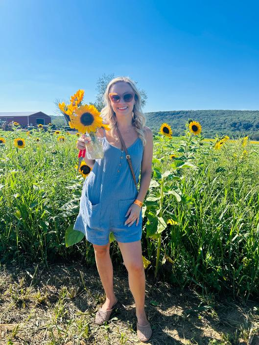 The founder of The Salt Haven smiling in a sunflower field